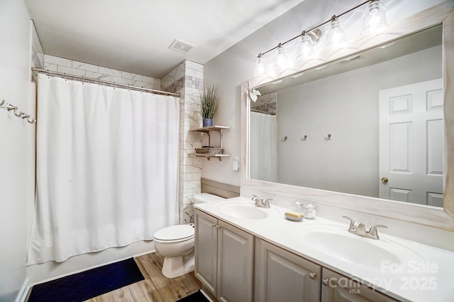 full bathroom featuring hardwood / wood-style flooring, shower / bath combination with curtain, vanity, and toilet