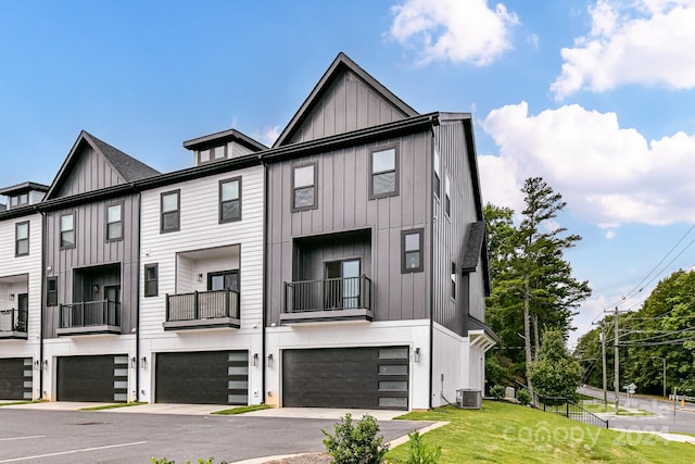 multi unit property featuring a balcony, a garage, a front yard, and central AC