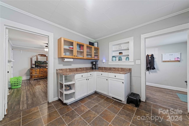 kitchen with built in shelves, crown molding, dark wood-type flooring, ceiling fan, and white cabinets