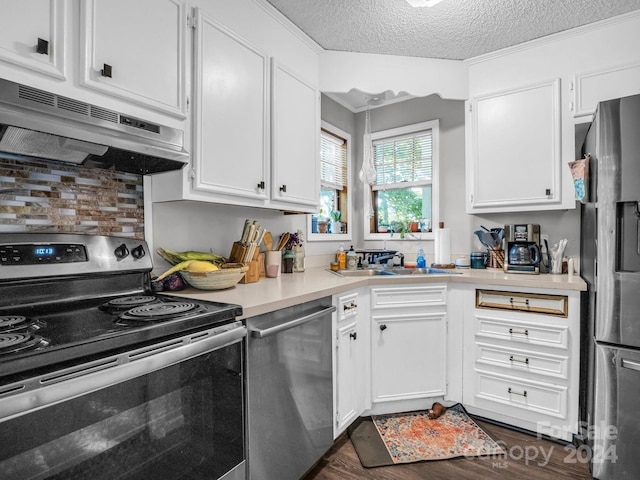 kitchen with appliances with stainless steel finishes, ventilation hood, a textured ceiling, and white cabinets