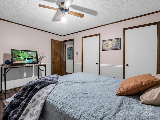 bedroom featuring ceiling fan, crown molding, hardwood / wood-style floors, and a textured ceiling