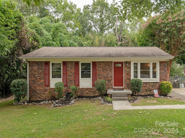 single story home featuring a front lawn