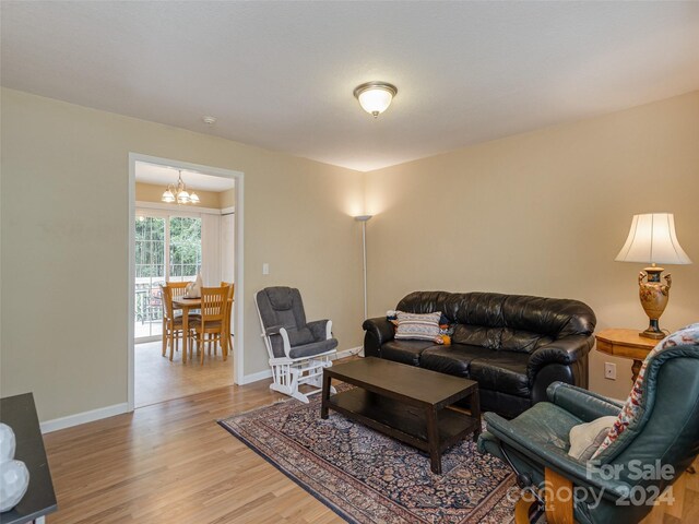 living room with an inviting chandelier and light hardwood / wood-style floors