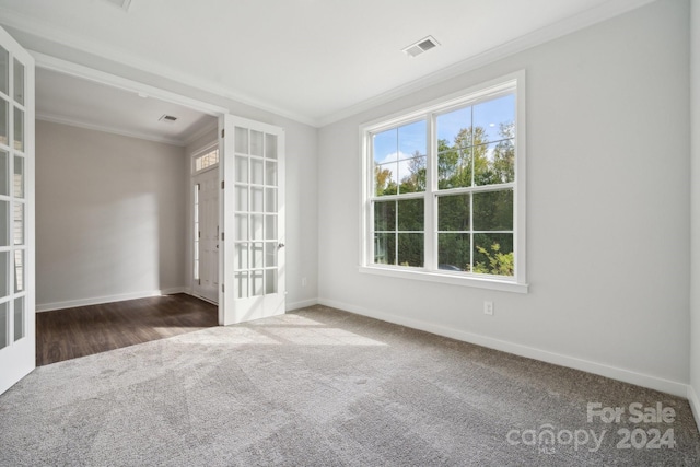 carpeted spare room featuring ornamental molding and french doors