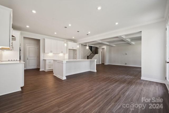 kitchen featuring pendant lighting, a center island with sink, dark hardwood / wood-style floors, white cabinets, and ornamental molding