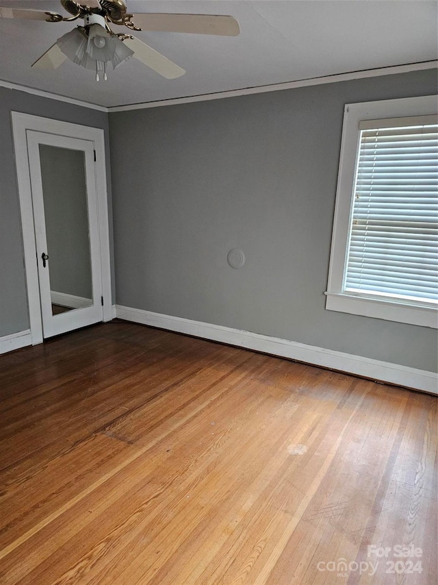 empty room with light wood-type flooring, crown molding, and ceiling fan