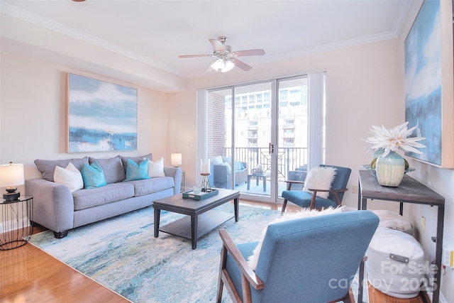 living area with ceiling fan, crown molding, and wood finished floors