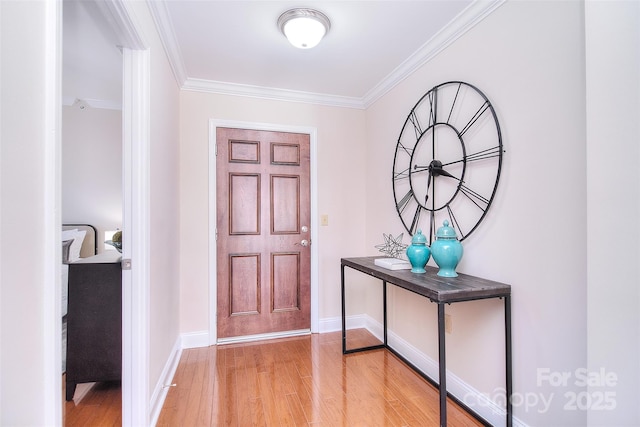 entrance foyer with baseboards, ornamental molding, and wood finished floors