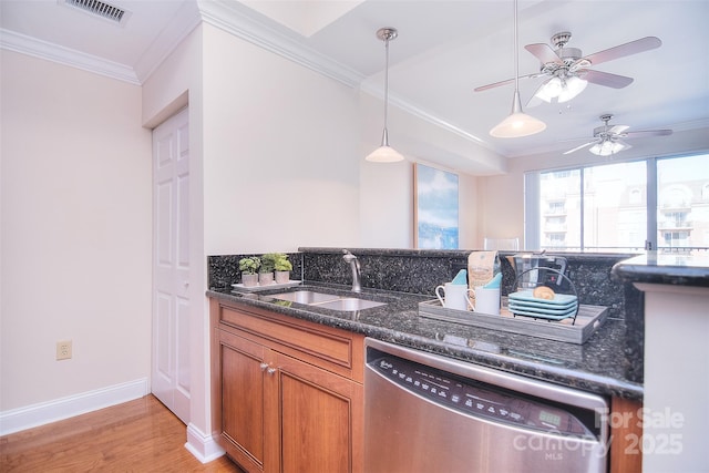 kitchen with visible vents, brown cabinetry, dark stone counters, stainless steel dishwasher, and a sink