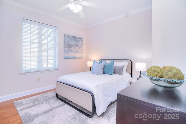 bedroom with baseboards, ceiling fan, wood finished floors, and crown molding