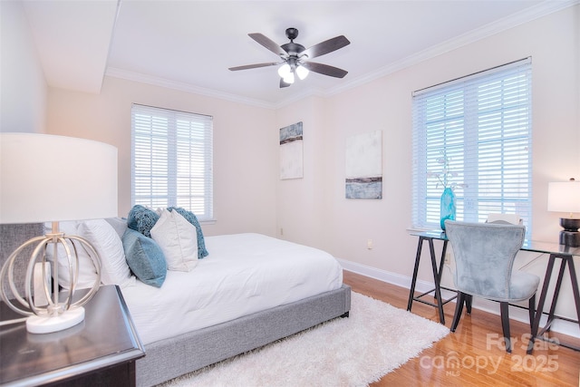 bedroom with baseboards, wood finished floors, a ceiling fan, and crown molding