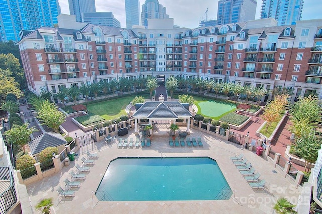 community pool with a patio area and a city view