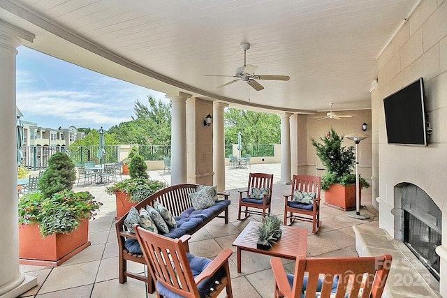 view of patio with an outdoor living space with a fireplace, ceiling fan, and fence