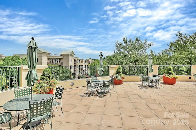 view of patio featuring outdoor dining area and fence