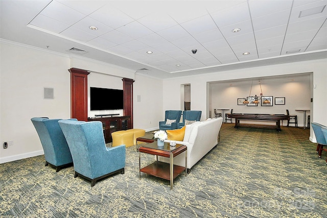 living area with decorative columns, dark carpet, baseboards, and ornamental molding