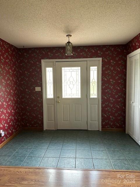 tiled entryway featuring a textured ceiling