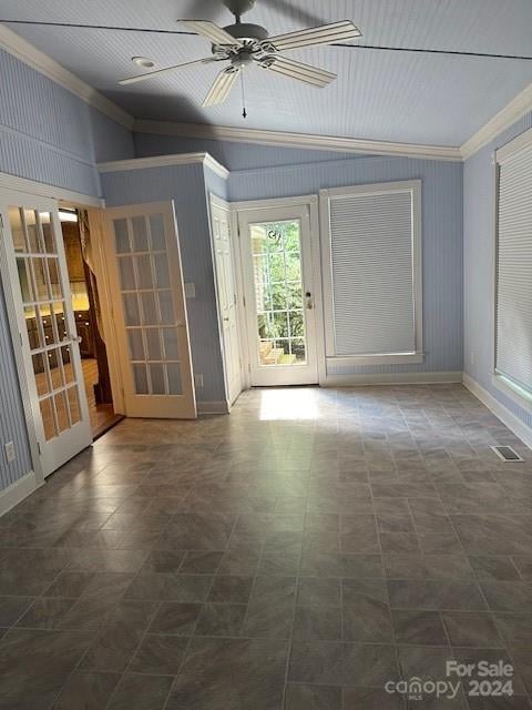 empty room featuring ceiling fan, ornamental molding, vaulted ceiling, and french doors