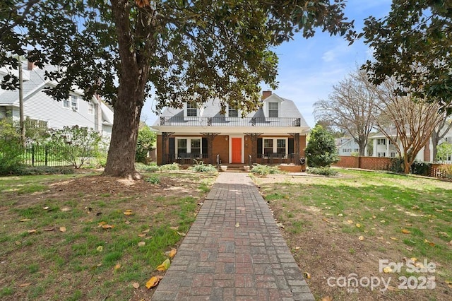 cape cod home featuring a porch and a front yard