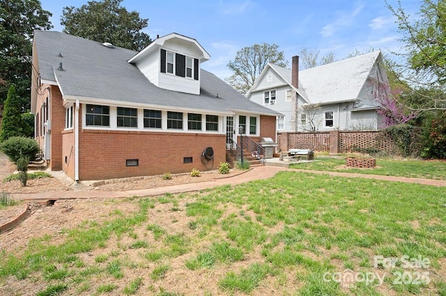 rear view of house featuring a lawn