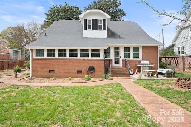 rear view of house featuring a lawn, a fire pit, and a patio area