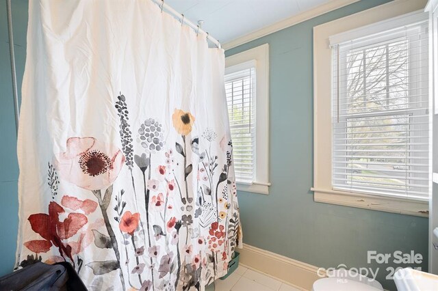 bathroom with toilet, tile patterned flooring, and crown molding