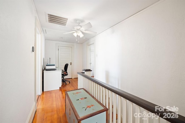 hallway featuring ornamental molding and light hardwood / wood-style flooring