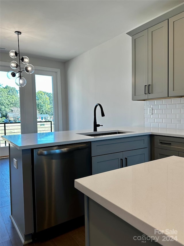 kitchen with stainless steel dishwasher, dark wood-type flooring, gray cabinetry, decorative light fixtures, and sink