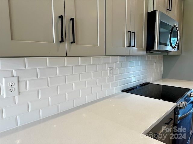 room details featuring gray cabinets, stainless steel appliances, and backsplash