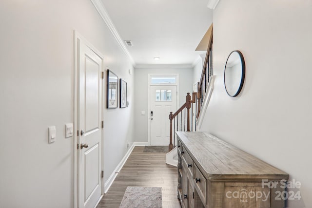 doorway to outside featuring crown molding and dark hardwood / wood-style flooring