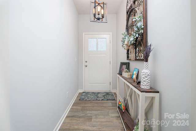 doorway featuring light hardwood / wood-style flooring and an inviting chandelier