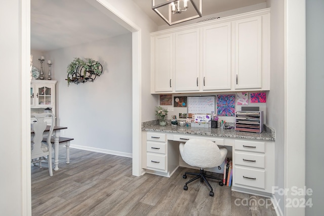 office space featuring light wood-type flooring and built in desk