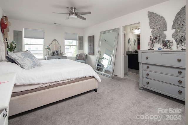 carpeted bedroom featuring ensuite bath and ceiling fan