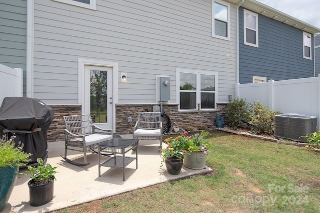 exterior space with cooling unit, a yard, and a patio