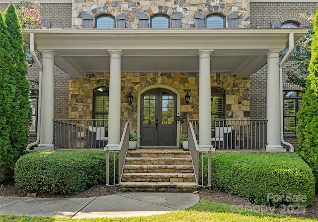 doorway to property featuring a porch and french doors