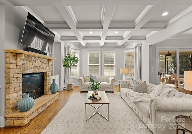 living room with beamed ceiling, coffered ceiling, a fireplace, and light wood-type flooring