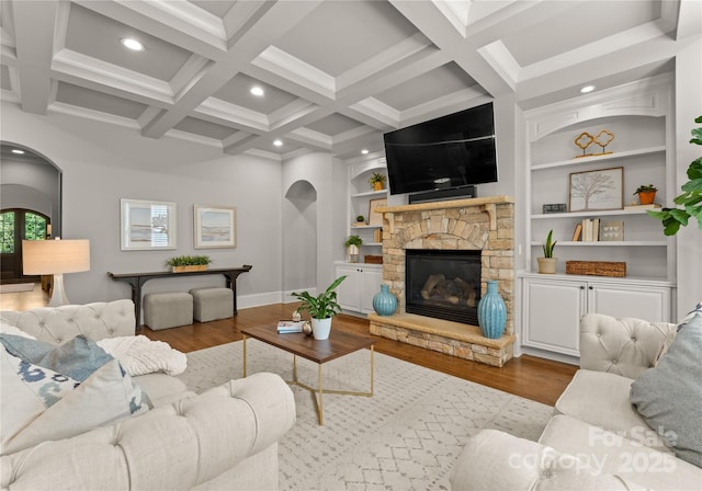 living room with hardwood / wood-style floors, beam ceiling, and a fireplace