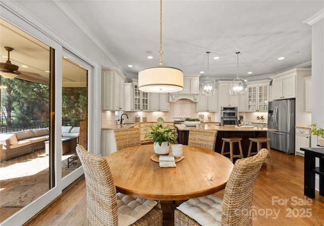 dining space featuring crown molding, dark hardwood / wood-style floors, and sink