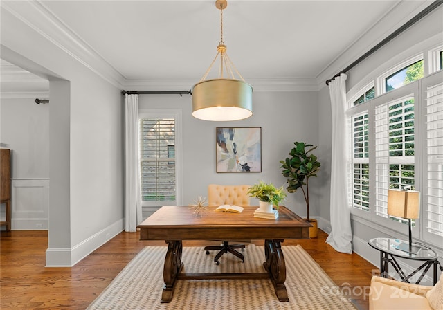 home office featuring hardwood / wood-style flooring, ornamental molding, and a healthy amount of sunlight