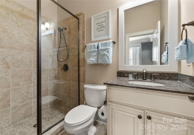 bathroom featuring vanity, toilet, and a shower with shower door