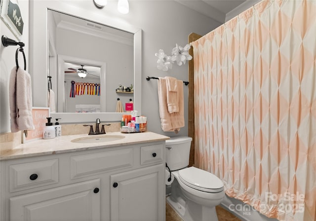 bathroom with vanity, crown molding, and toilet