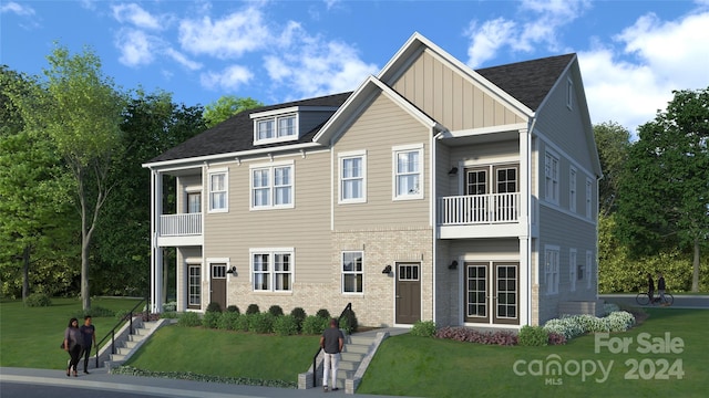 view of front of house featuring a balcony and a front lawn