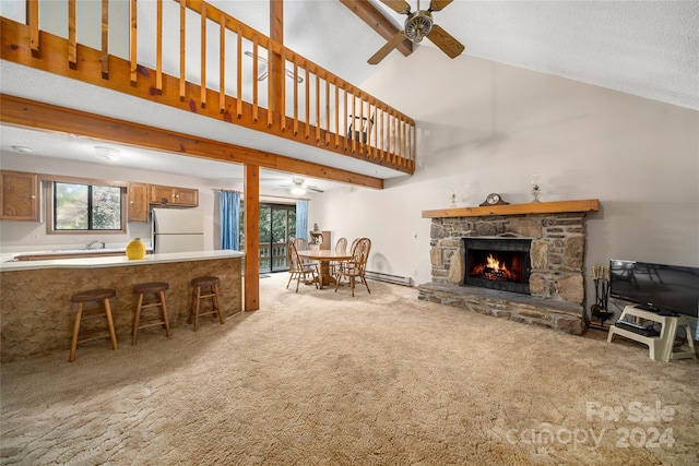 carpeted living room featuring high vaulted ceiling, a textured ceiling, a baseboard radiator, ceiling fan, and a stone fireplace