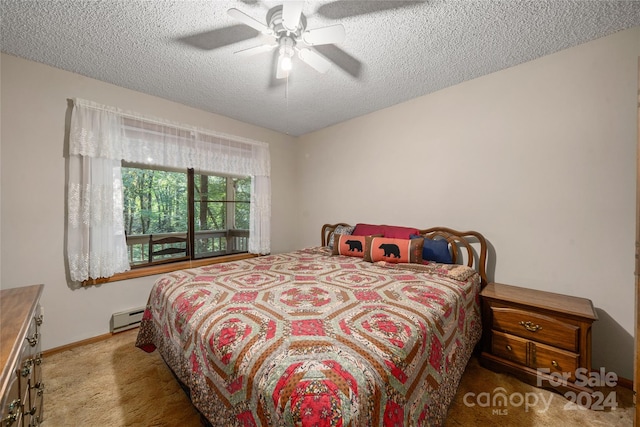 bedroom featuring a baseboard heating unit, a textured ceiling, ceiling fan, and carpet flooring