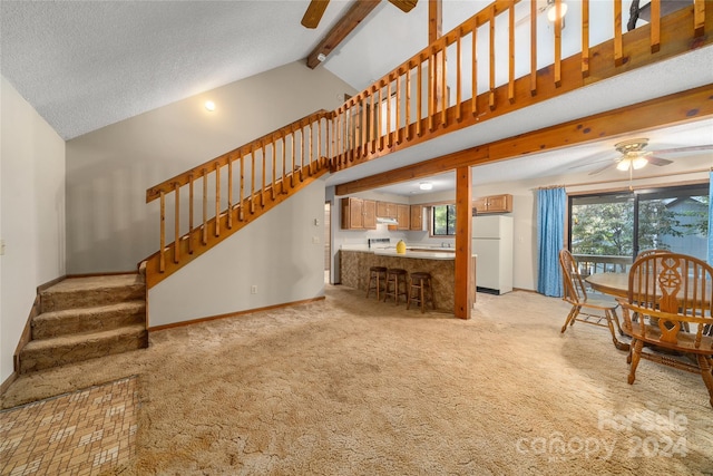 carpeted living room featuring a wealth of natural light, ceiling fan, beam ceiling, and a textured ceiling