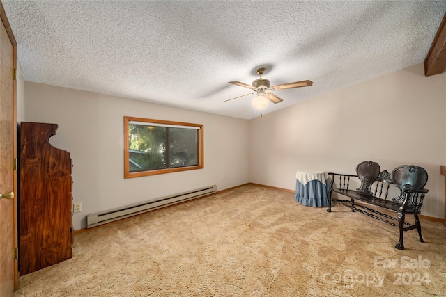 sitting room featuring a baseboard heating unit, ceiling fan, light carpet, and a textured ceiling