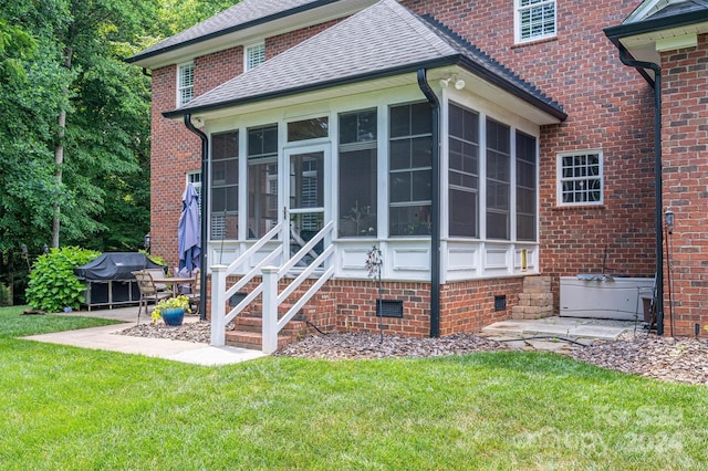 rear view of property with a yard and a sunroom