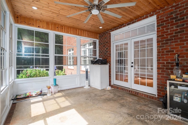 unfurnished sunroom featuring french doors, ceiling fan, and plenty of natural light