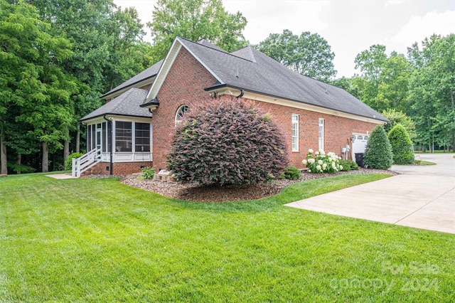 view of home's exterior with a yard and a sunroom