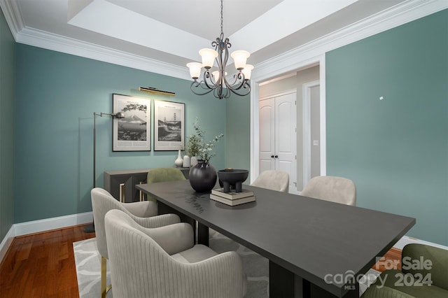 dining space featuring ornamental molding, dark wood-type flooring, and an inviting chandelier