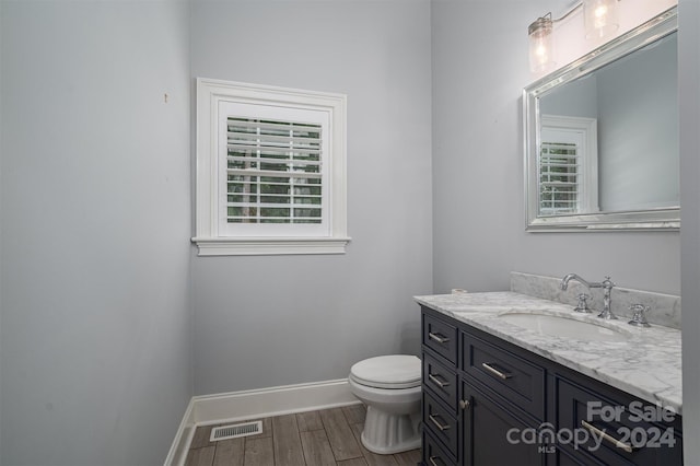 bathroom with vanity, toilet, and hardwood / wood-style flooring